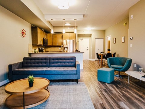 a living room and kitchen with blue couches and chairs